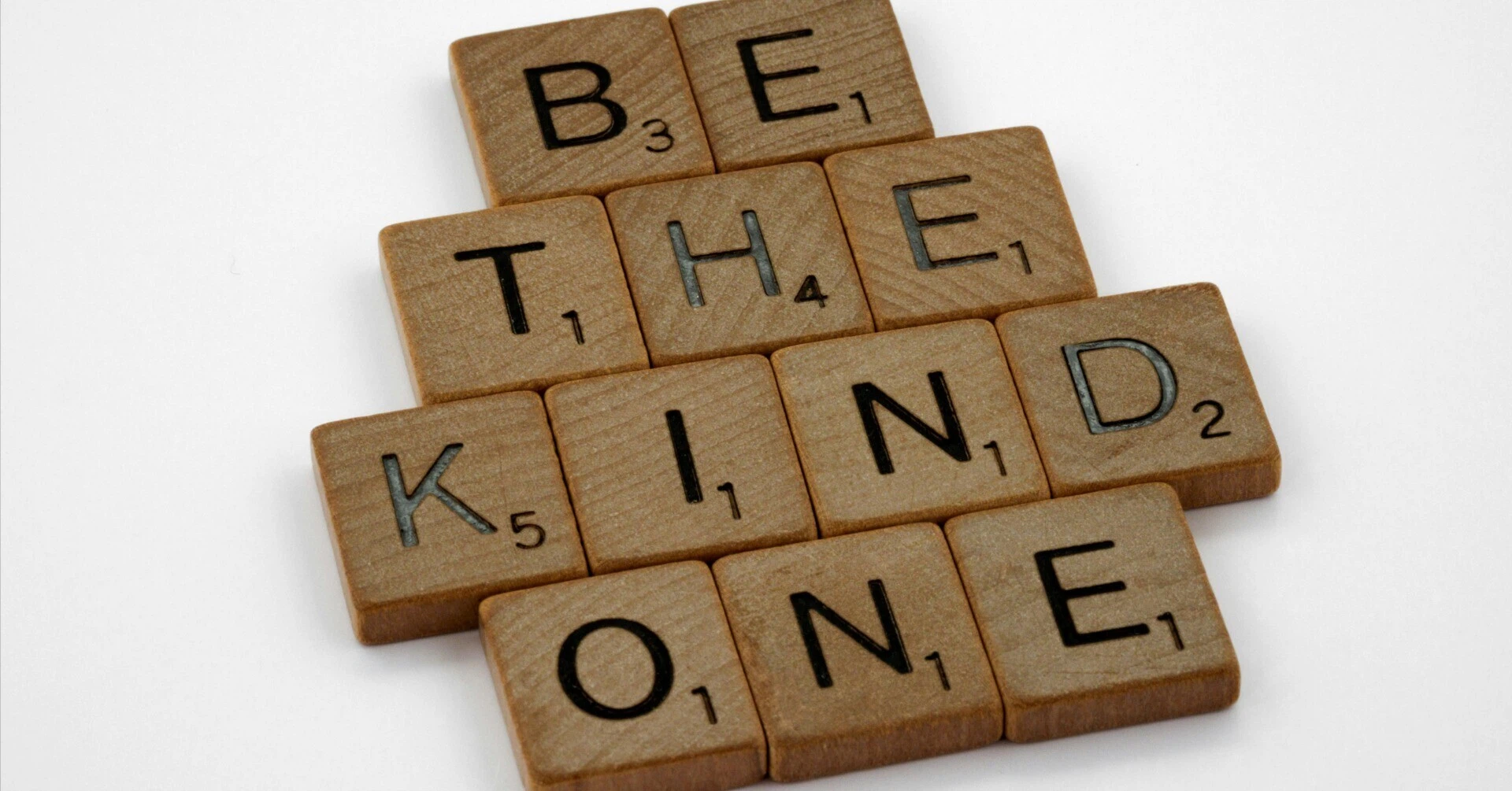 スクラブルの文字タイルで「BE KIND（親切になろう）」という言葉が作られている。企業の社会的責任（CSR）の根底にある、他者を思いやる気持ちを象徴する写真。