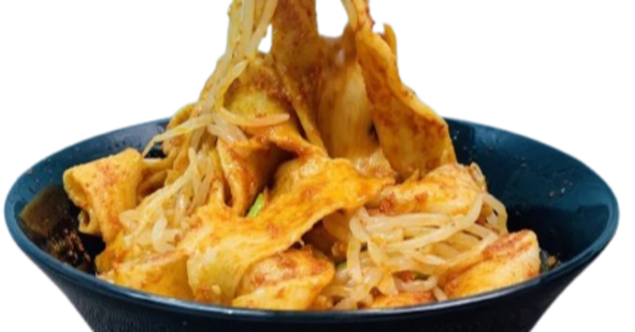 箸で持ち上げられたビャンビャン麺のクローズアップ。唐辛子やネギが絡んだ幅広の麺が美味しそうに湯気を立てている。
