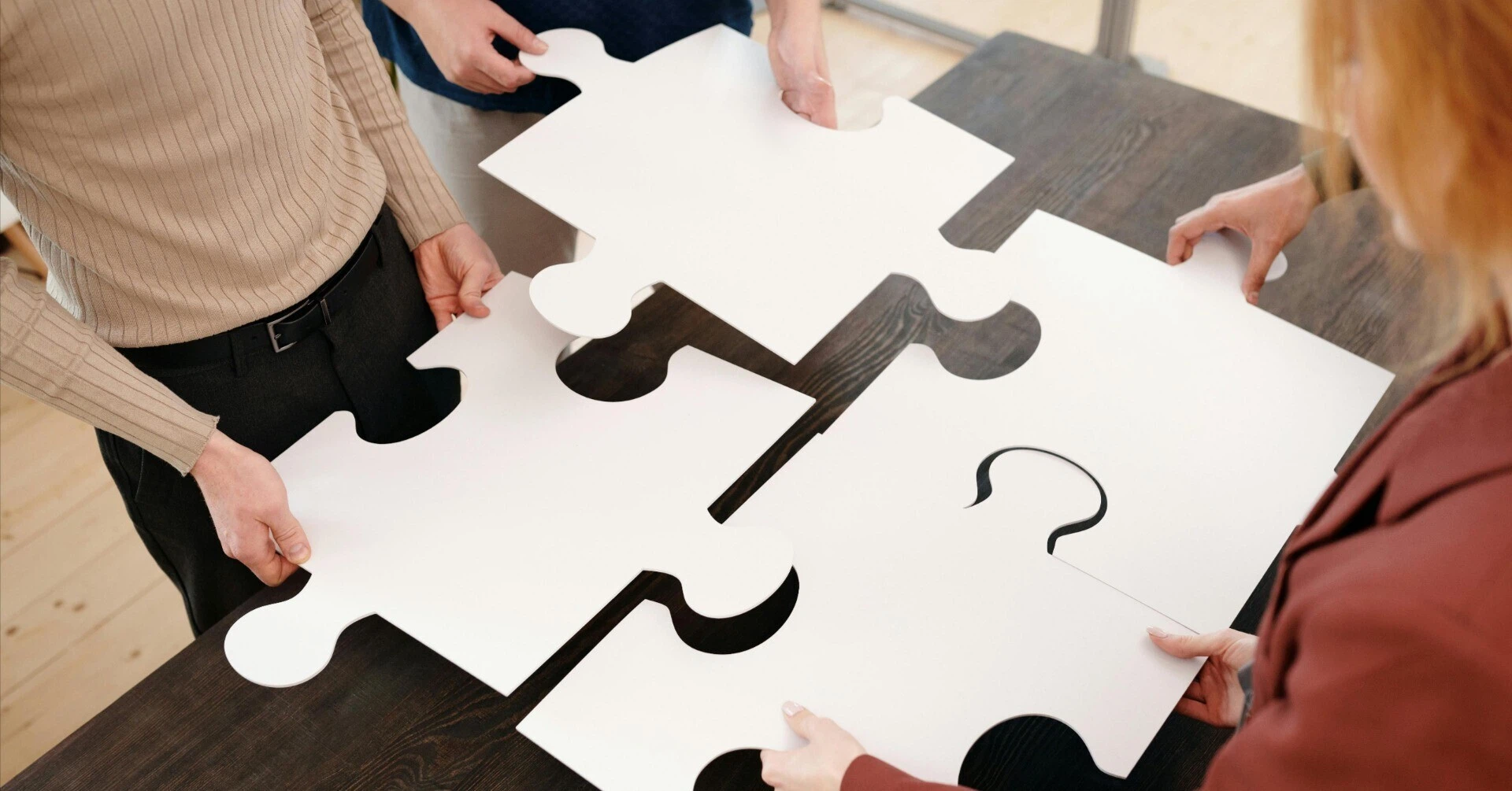 Team members working together to complete a puzzle, symbolizing responsibility and collaboration.