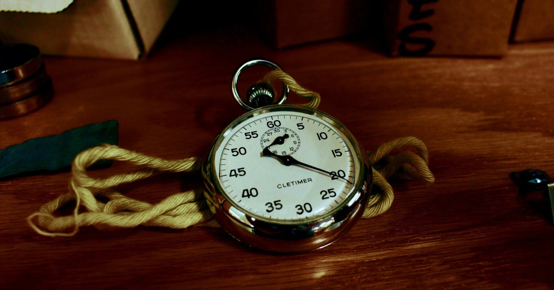 An analog stopwatch on a wooden table, symbolizing time management and efficiency.