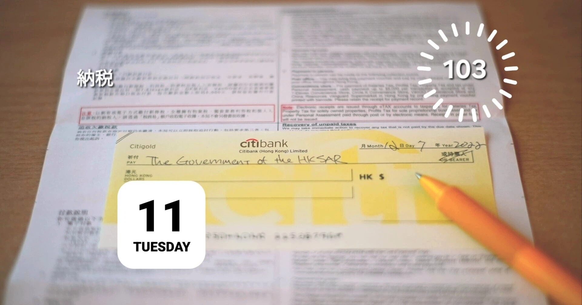 香港政府（HKSAR）宛ての納税用小切手、税務署からの申告用紙、ペン、カレンダー