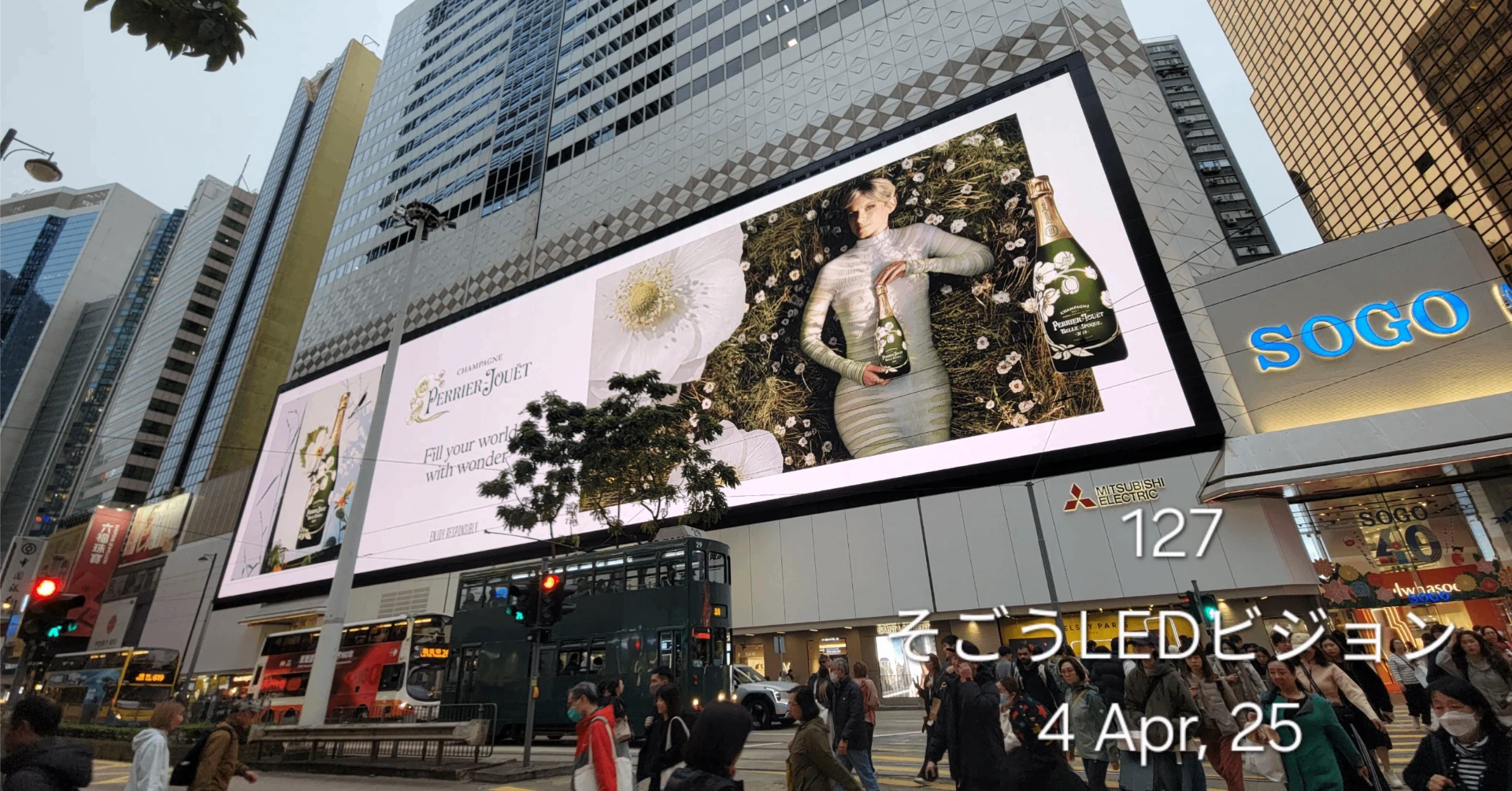 香港・銅鑼湾(コーズウェイベイ)の交差点にそびえ立つ、巨大なそごう(SOGO)のLEDビジョンと行き交う人々