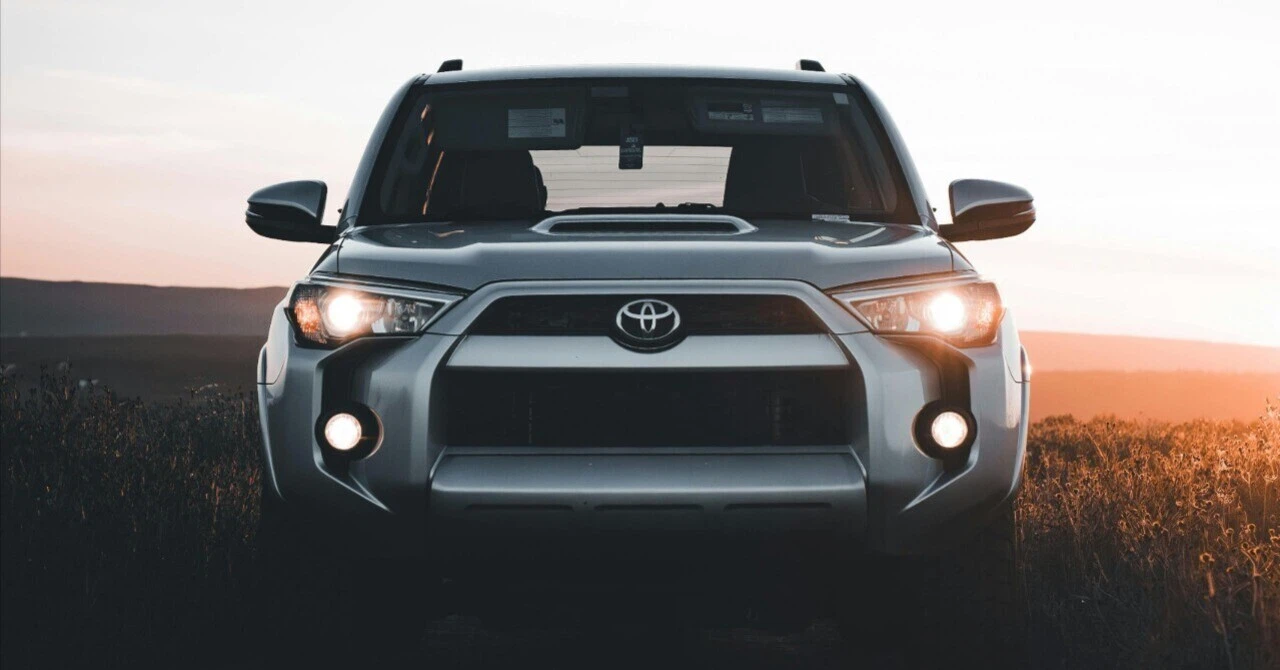 A front photo of a Toyota SUV (4Runner) against the sunset, symbolizing Japanese technological prowess and global brand value.