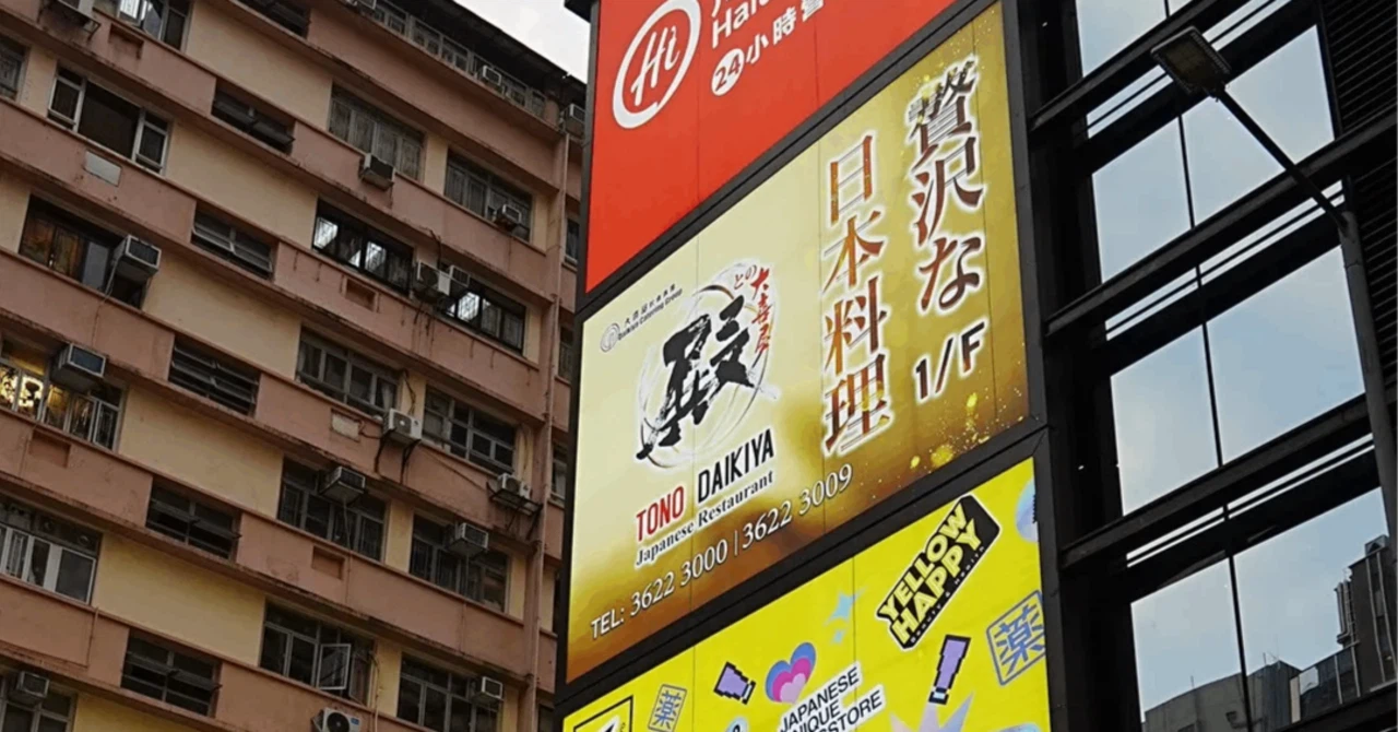 香港・尖沙咀(TST)のビル壁面に掲げられた「贅沢な日本料理」とアピールする大喜屋と、マツモトキヨシの目立つ看板