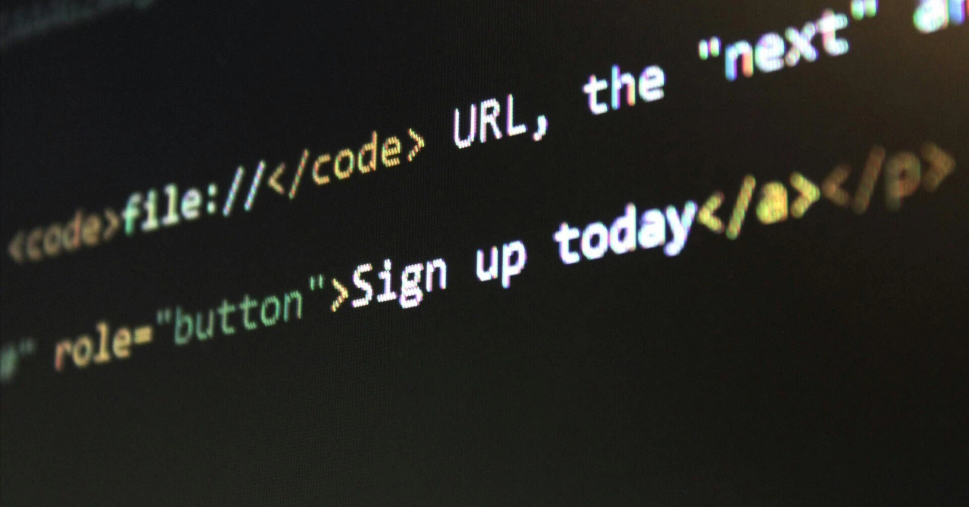 A monitor screen displaying HTML code that makes up URLs and sign-up buttons