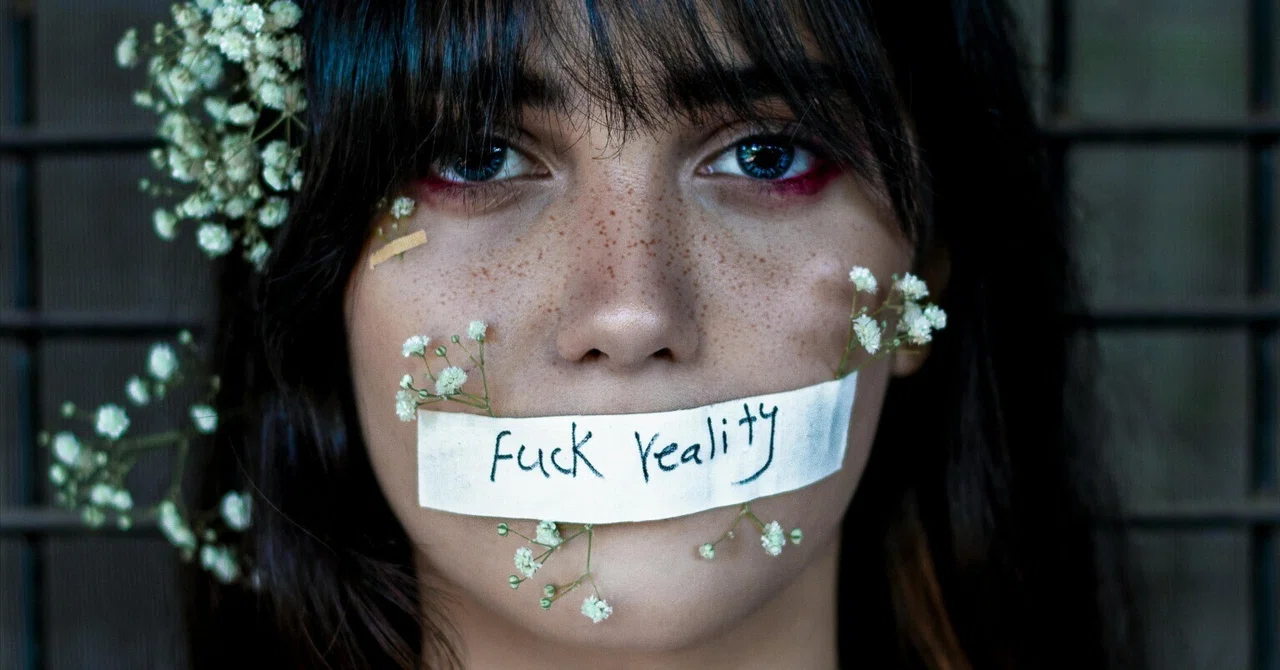 A portrait of a woman with her mouth taped shut with the words "Fuck reality," adorned with small white flowers on her face.