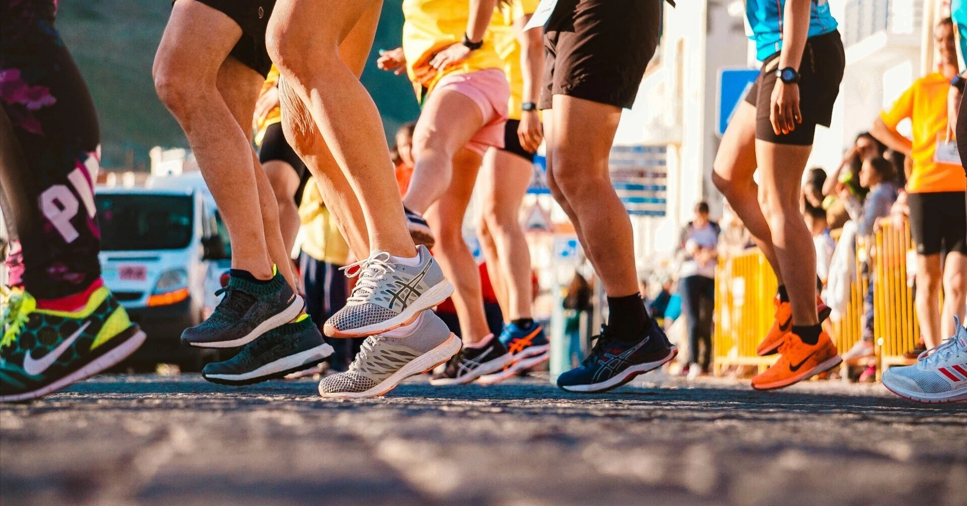 The feet of runners wearing sneakers starting to run all at once, symbolizing real-world events like the Nike Run Club