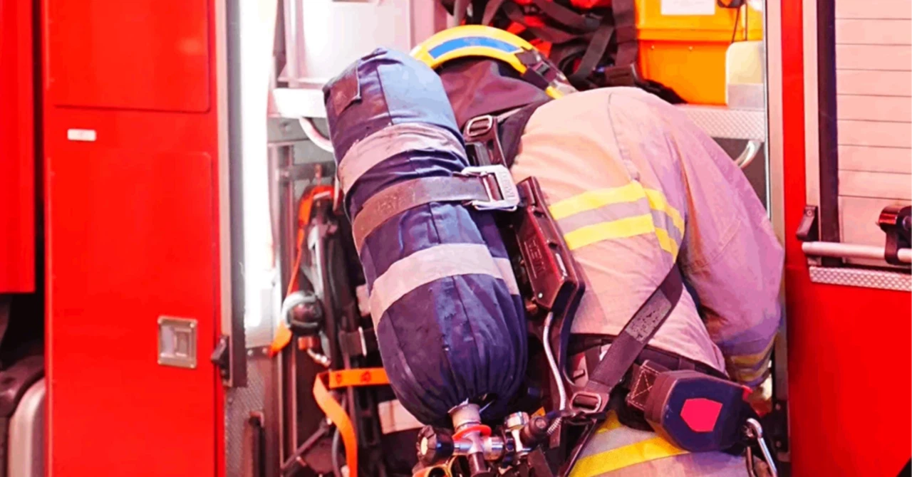 背中に「FIRE SERVICES」と書かれたユニフォームを着て出動する、香港消防処(消防隊)の隊員と赤い消防車