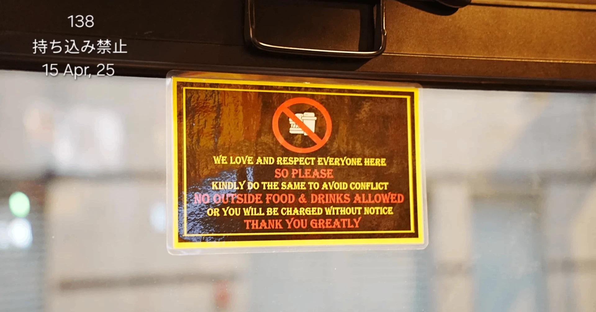 飲食店の窓ガラスに貼られた「NO OUTSIDE FOOD & DRINKS ALLOWED（飲食物の持ち込み禁止）」を伝える英語の注意書きサイン