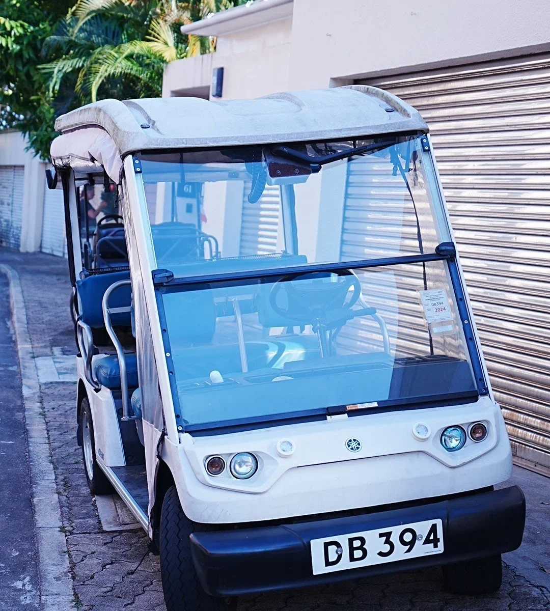 ディスカバリー・ベイの路上に駐車された、DBのナンバープレートが付いた白い電動カート