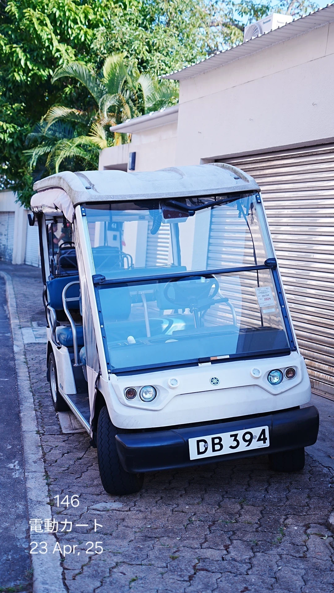 ディスカバリー・ベイの路上に駐車された、DBのナンバープレートが付いた白い電動カート