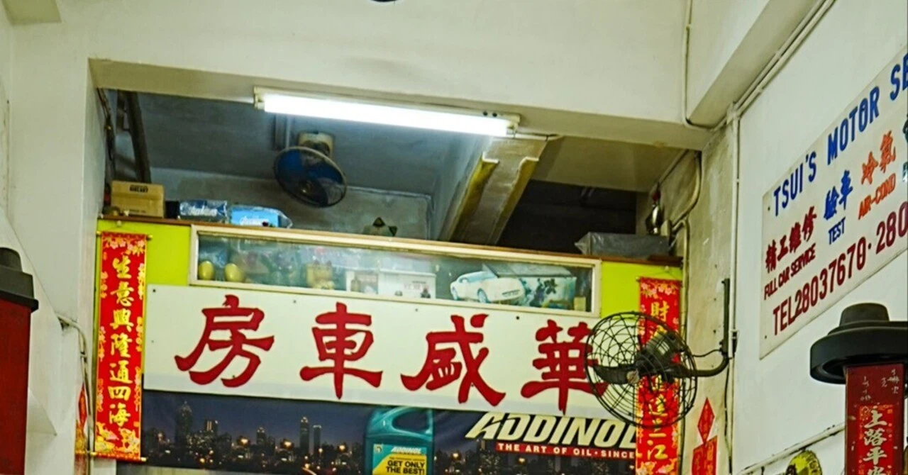 漢字の看板や古い扇風機が残る、香港の路地裏にある昔ながらの自動車整備工場